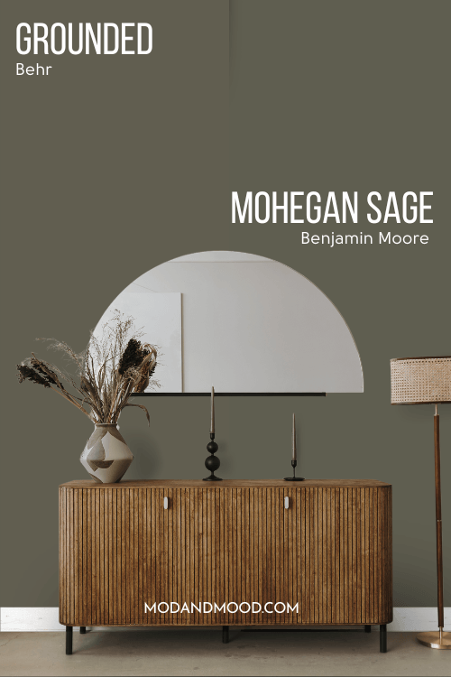 Behr Grounded on half of the wall and Mohegan Sage on the other half behind a wood hall table and half moon mirror.